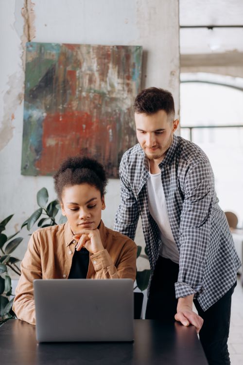 Free A man and woman working together on a laptop in a stylish office. Stock Photo
