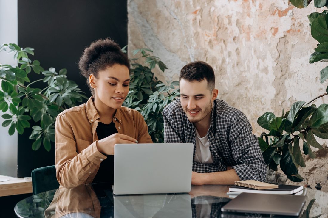 Two of us reviewing paper stock at a desk — photo by Mikhail Nilov on Pexels