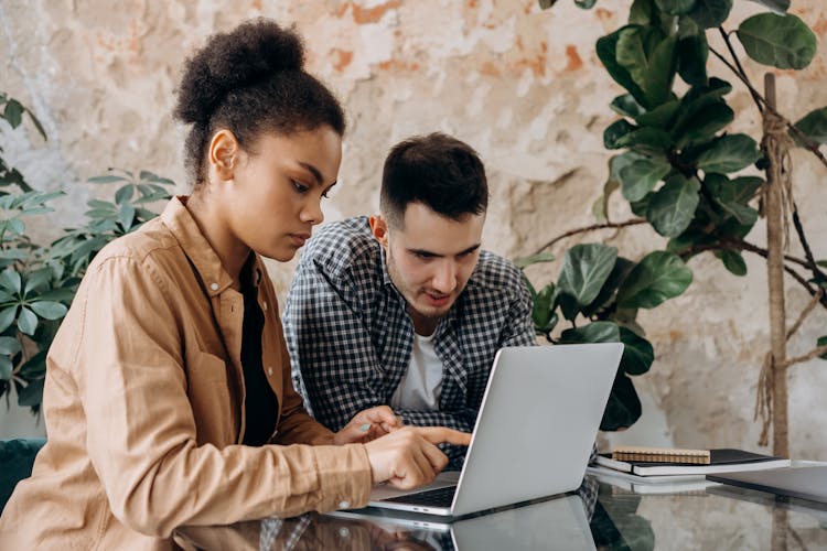 Man And Woman Sitting On Chair Using Laptop Computer