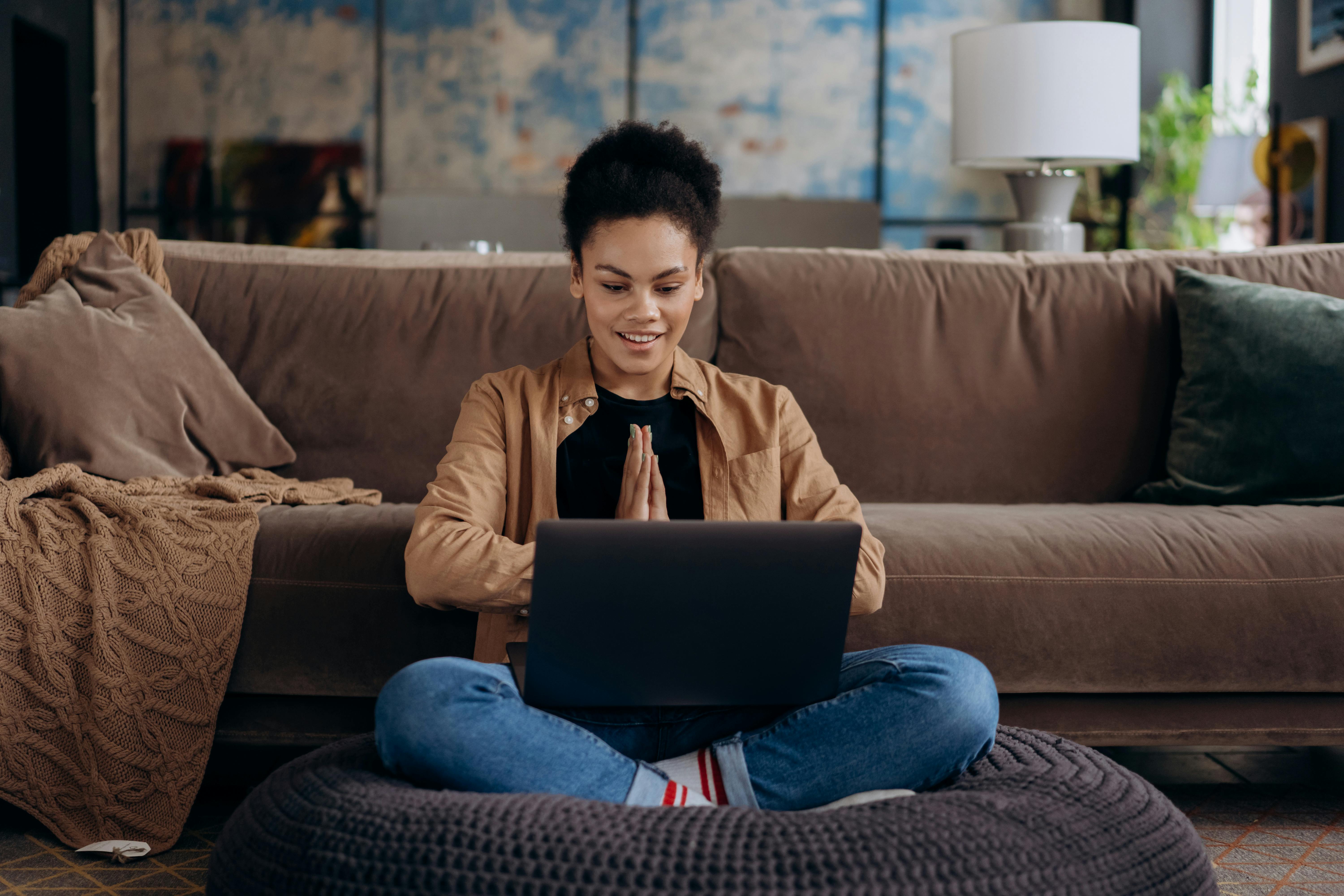 Une femme travaillant à distance sur son ordinateur portable dans un environnement confortable