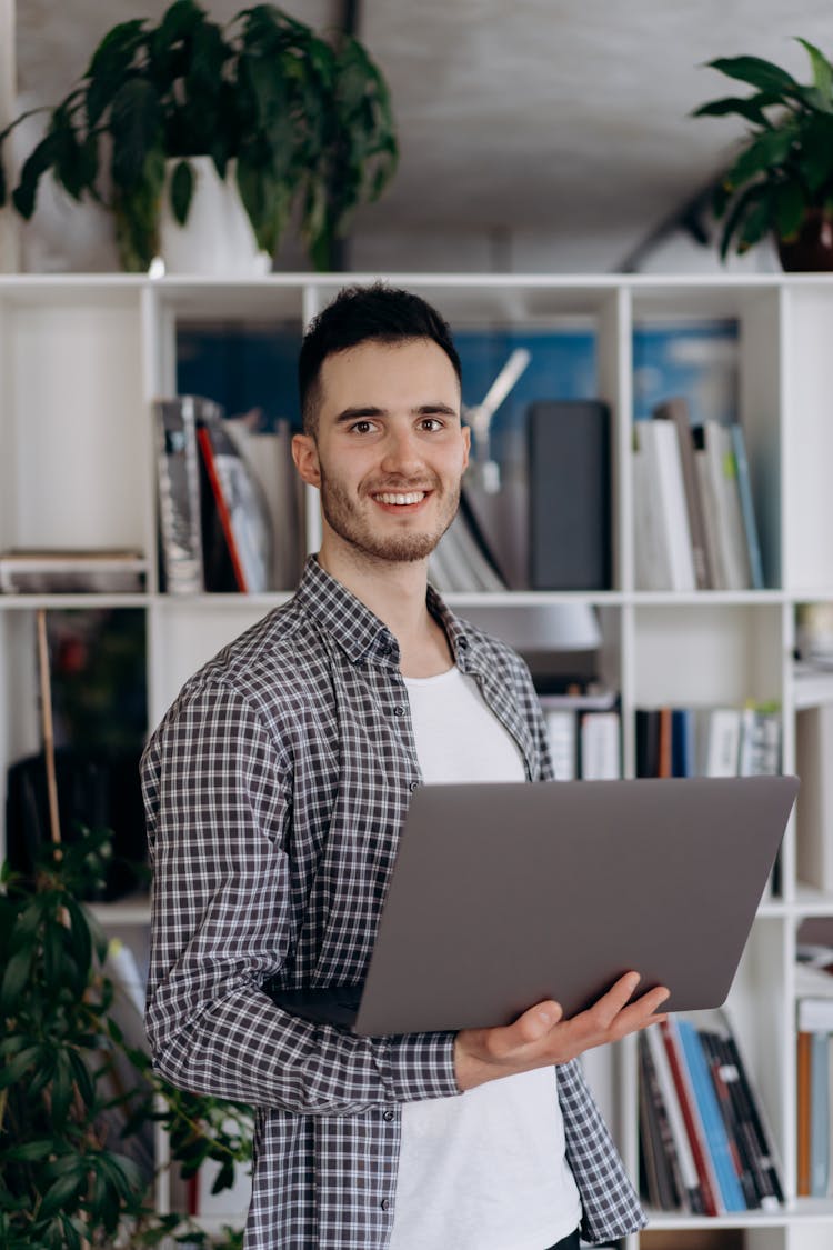 A Man Smiling Carrying A Laptop