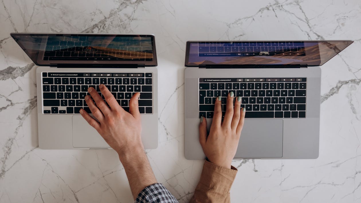 Two People With Their Hands On A Laptop · Free Stock Photo