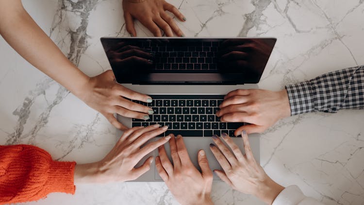 People Touching A Laptop