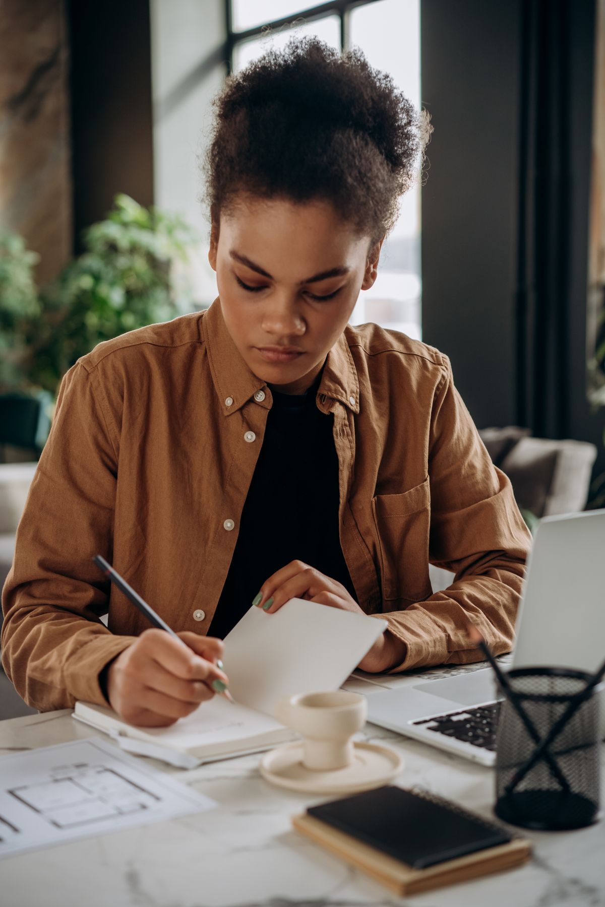 Person reviewing household budget and planning on laptop at home desk
