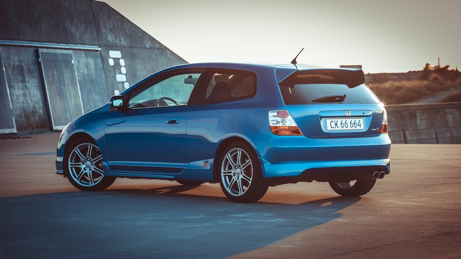 Blue Honda Hatchback on Concrete Pavement