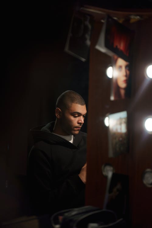 Free Man in Black Coat Sitting Infront Of A Mirror Stock Photo