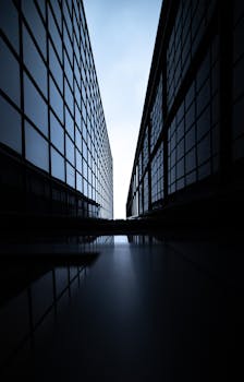 Dramatic view between two modern skyscrapers with glass facades, emphasizing symmetry.