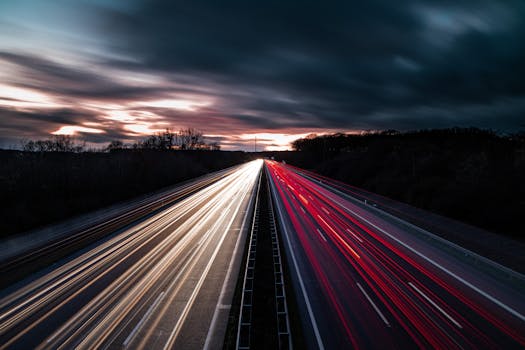 Stunning long exposure of highway light trails during twilight showcasing movement and speed.
