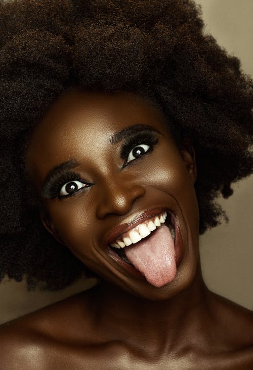 Free Woman With Black Curly Hair Smiling and Showing Tongue Stock Photo