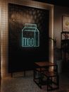 Neon signboard with milk box and word moo near table