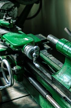 Close-up of an old green metalworking machine in an industrial setting. - Fotografer Sidoarjo