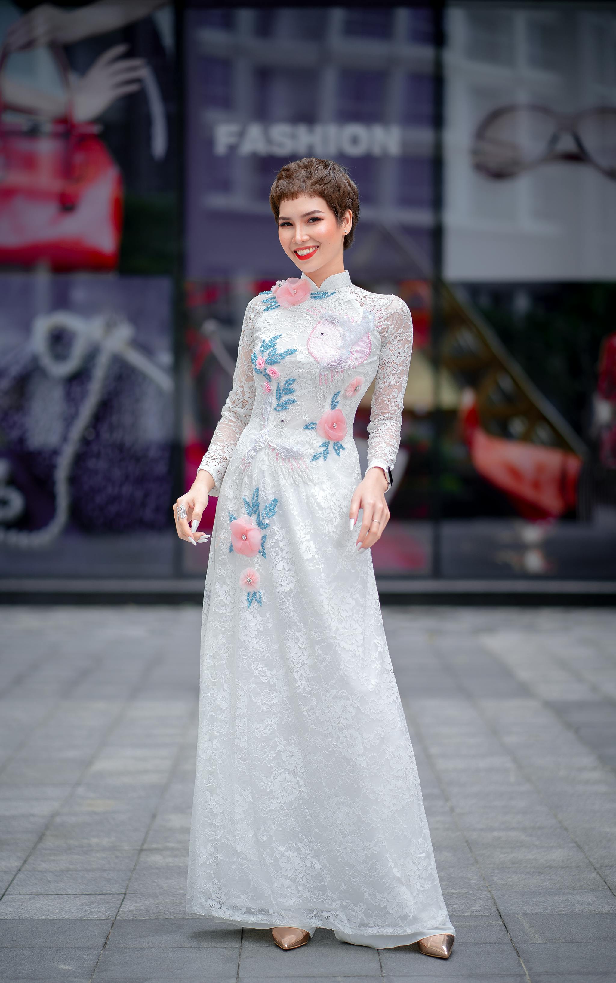 woman in white floral long dress standing on gray pavement