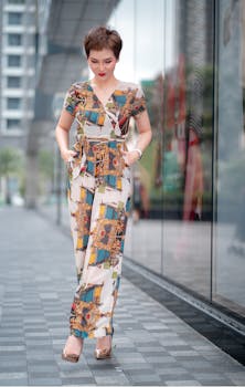 Fashion model in a patterned jumpsuit walking along a city street.