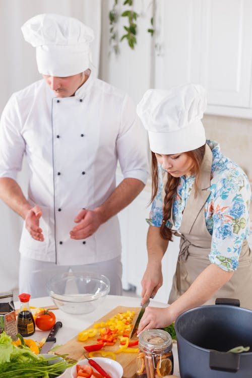 Man in White Chef Hat and Woman in Blue and White Floral Dress