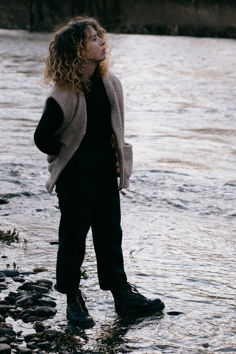 A Woman With Fleece Sweater Standing Near The River