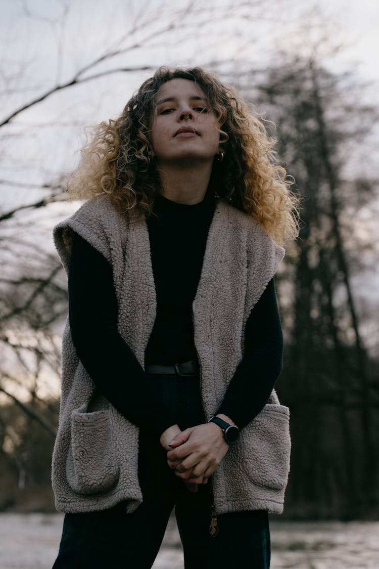 A Woman With Curly Hair Wearing A Fleece Sweater