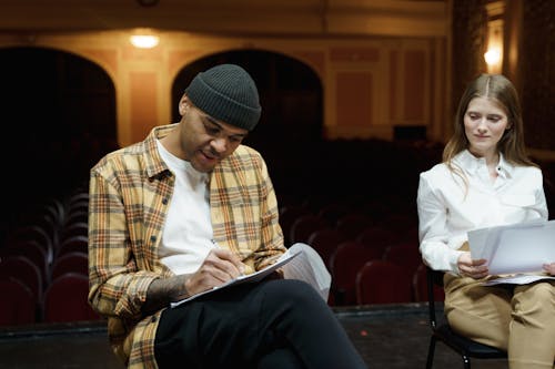 Man In Plaid Shirt Writing On A Paper