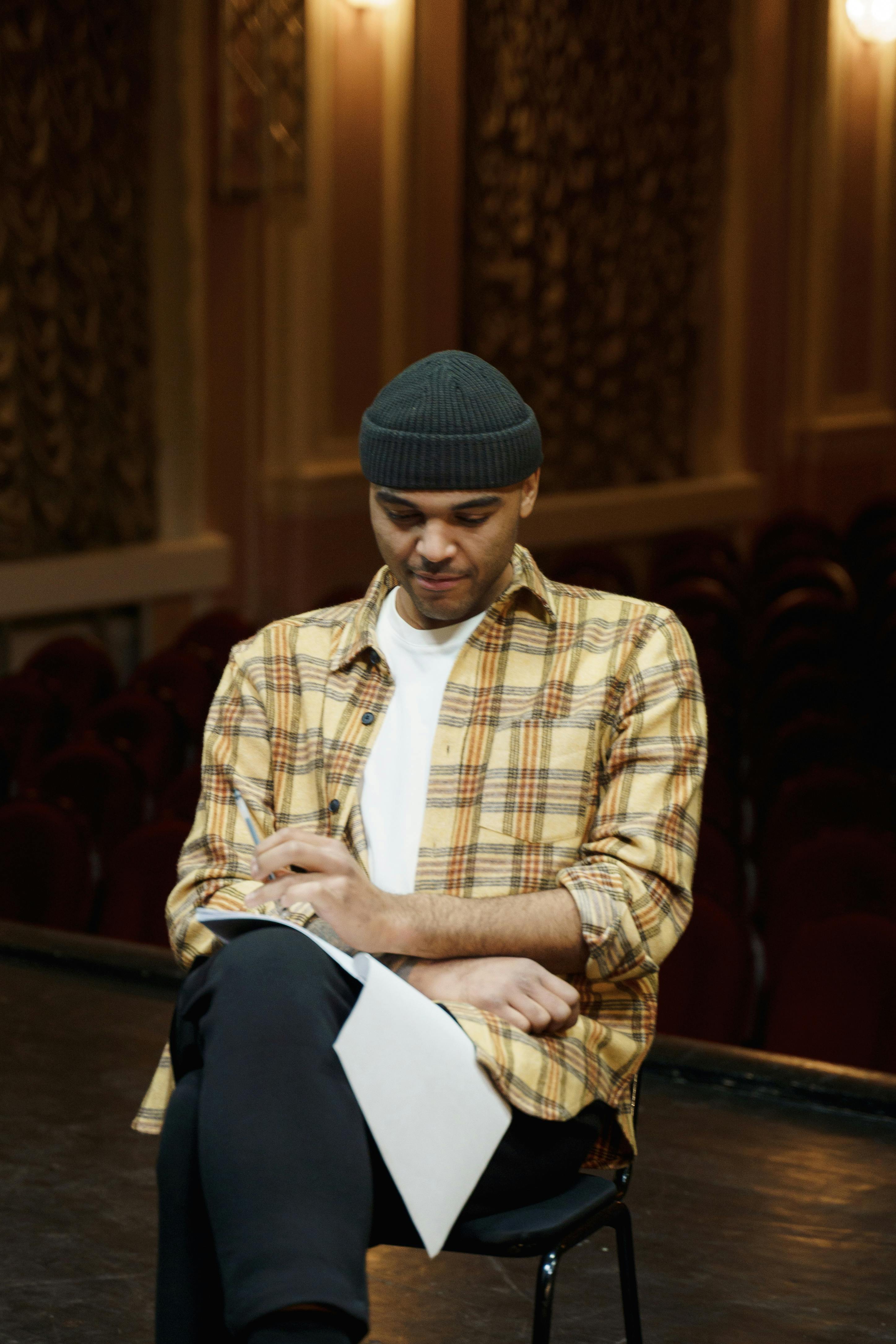 man in plaid shirt reviewing his script