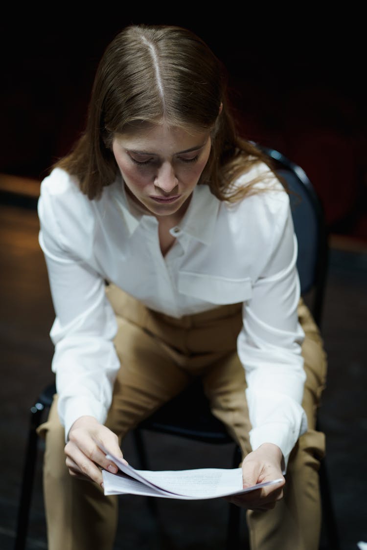 Woman In White Dress Shirt Reading A Script