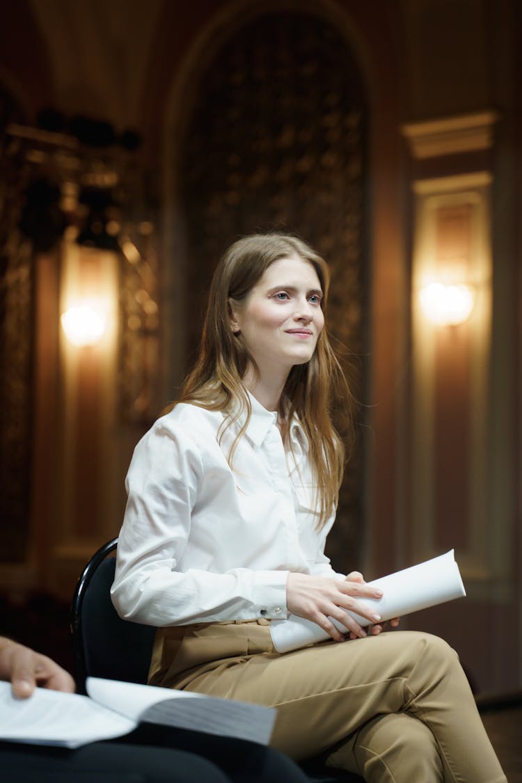 Woman In White Shirt Holding A Script