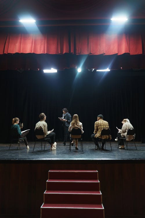 Group of People Sitting on Chair on Stage