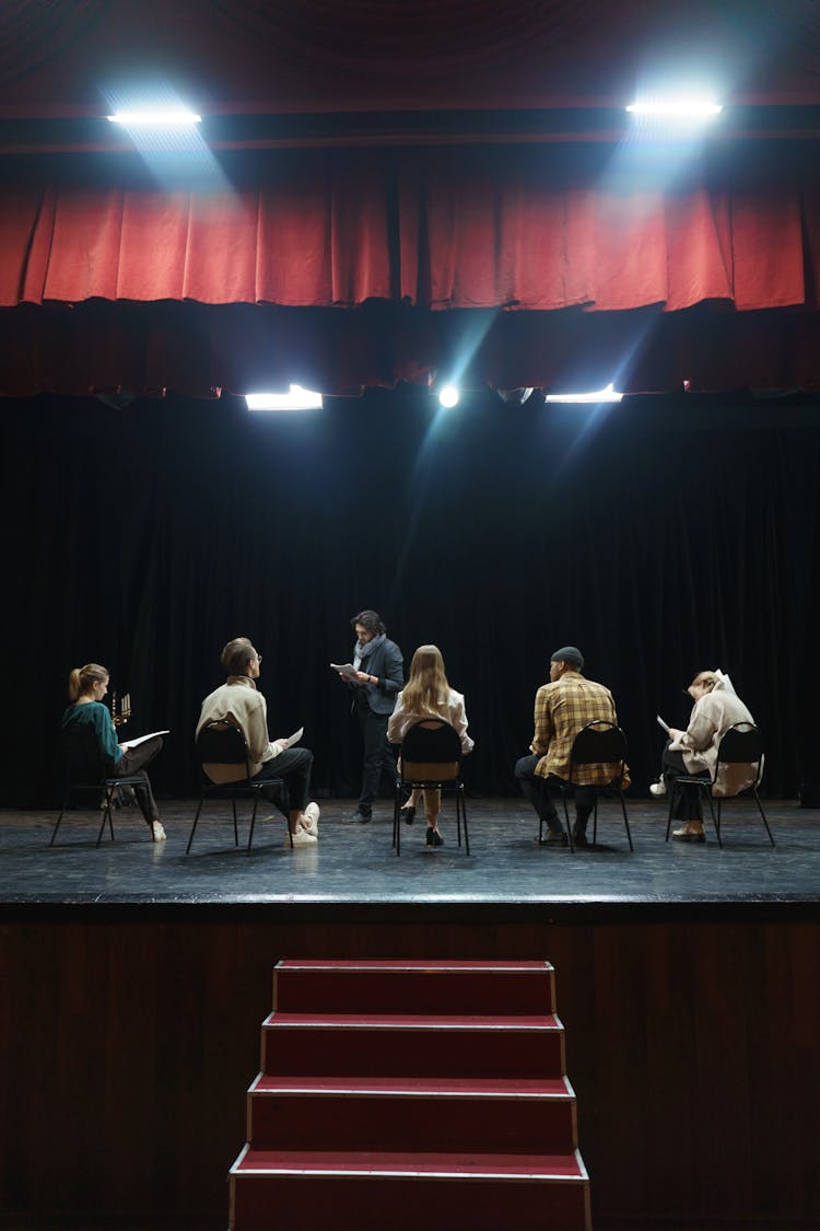 Group Of People Sitting On Chair On Stage