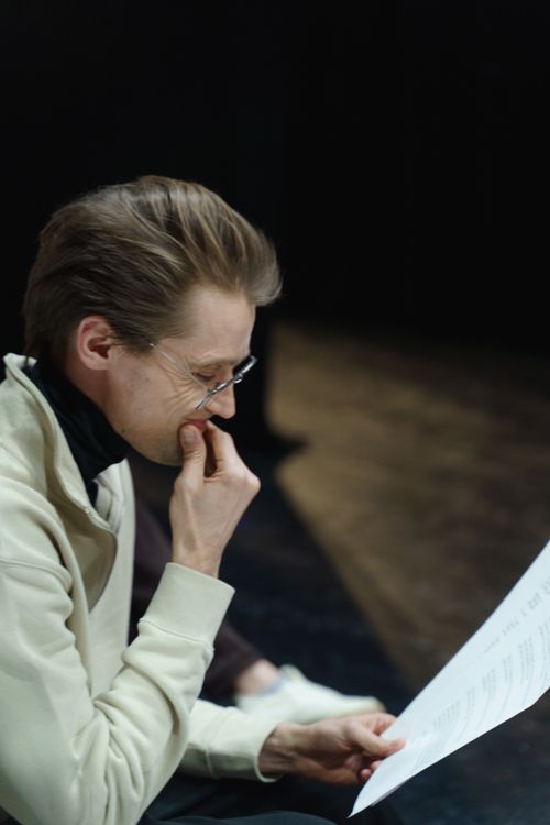 Free A focused male actor rehearses his script indoors at a theater. Stock Photo