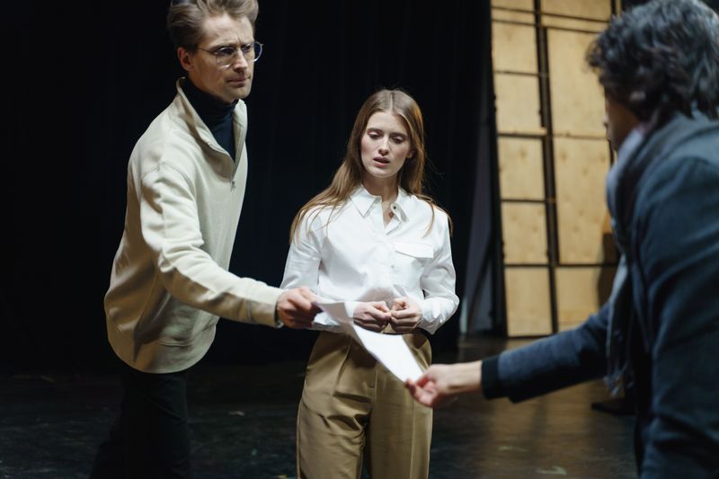 Acting coach handing a student a script during a lesson
