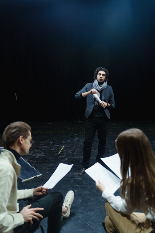 Man And Woman Holding Scripts Of The Play