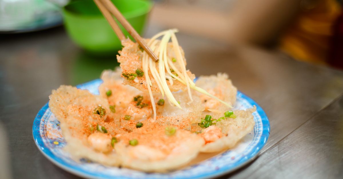 Close-up of Vietnamese shrimp rice chips being enjoyed with chopsticks in Vũng Tàu.