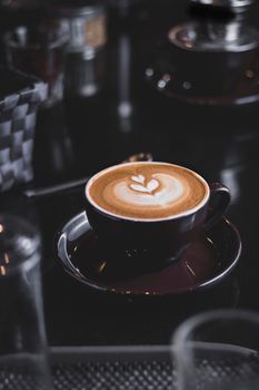 Artistic cappuccino with heart-shaped latte art in a cozy cafe ambiance, perfect for coffee lovers.