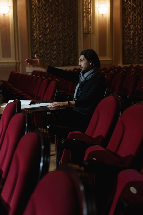 Man in Black Shirt Sitting on Red Chair