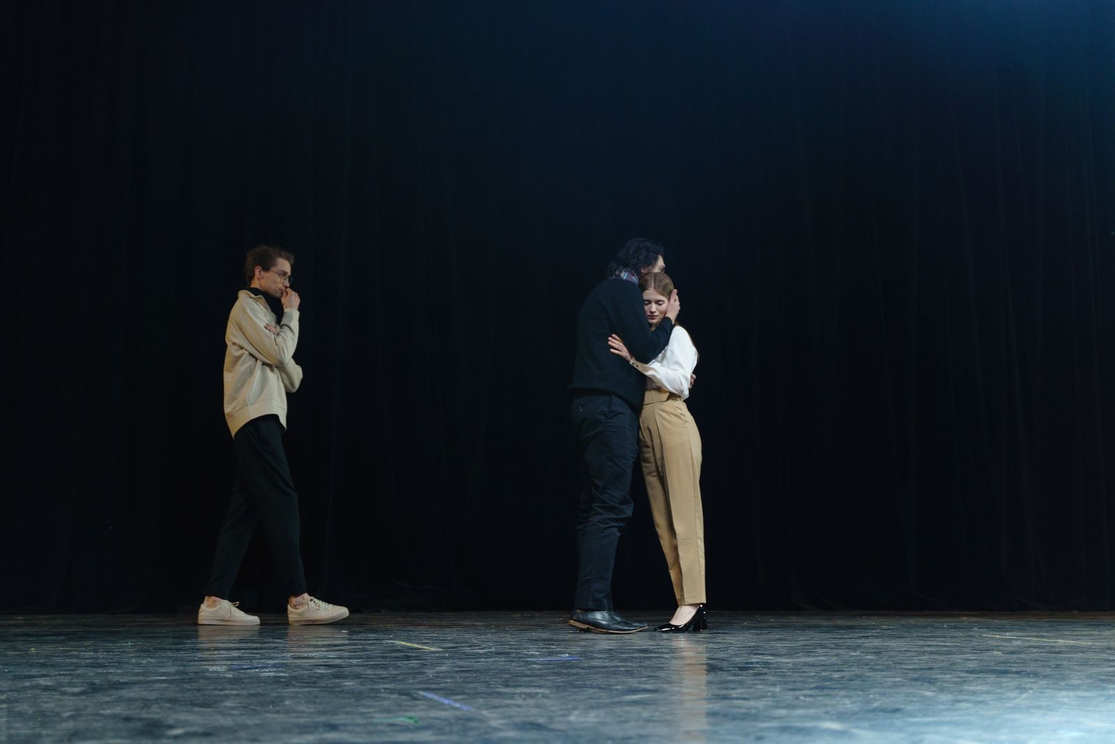 Three people mid scene on a stage