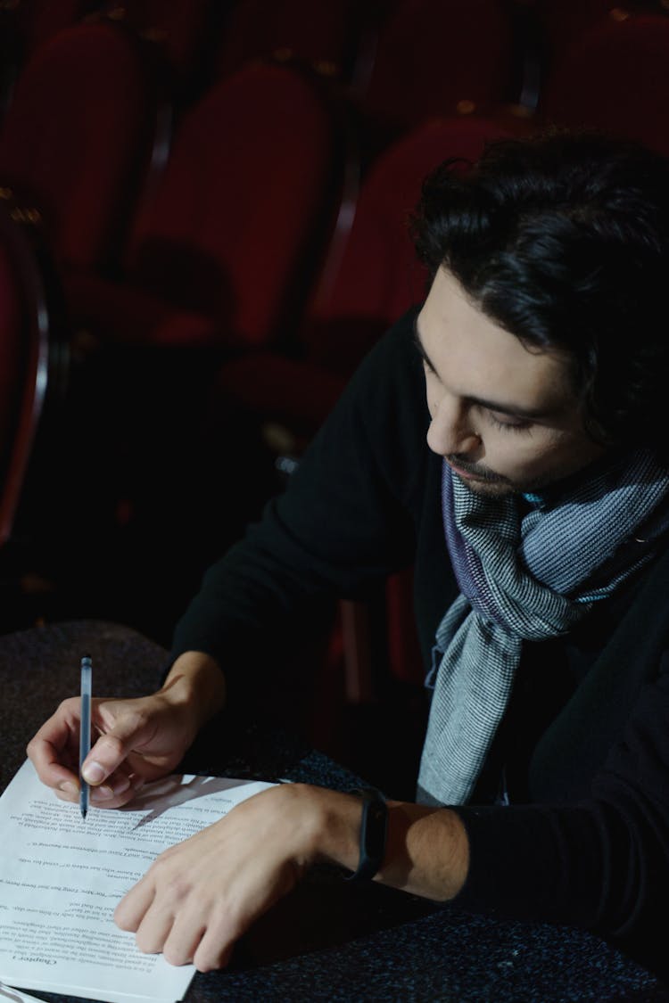 Man In Black Suit Jacket Writing On White Paper