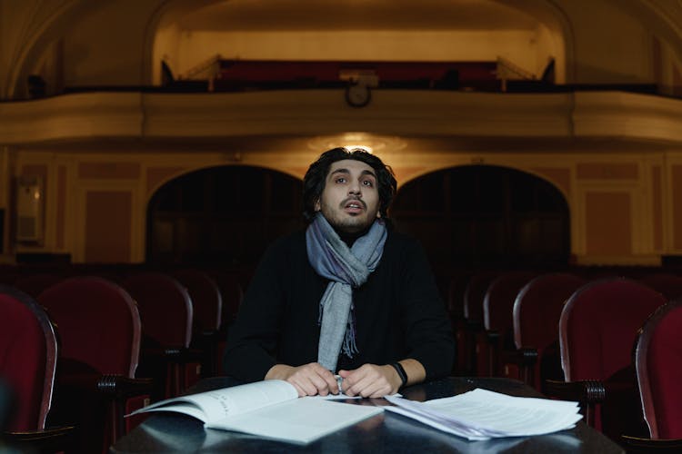 Man Sitting On Chair Looking At The Stage