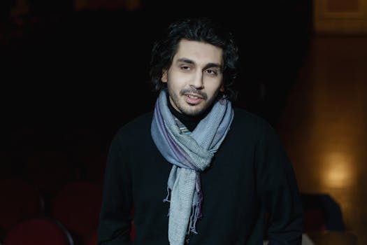 A portrait of a man wearing a scarf indoors, capturing a theatrical ambiance.