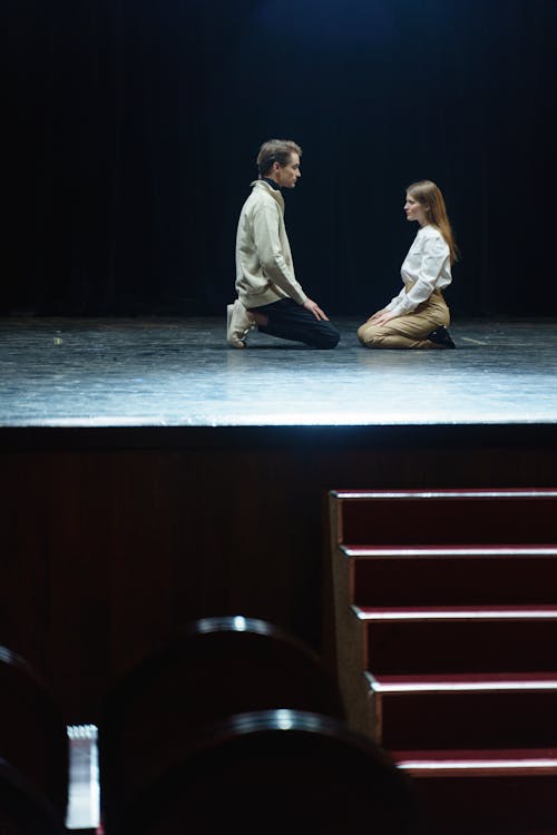 Man And Woman On Stage In A Kneeling Position