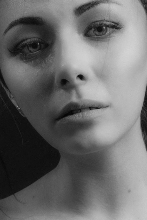 Free A close-up black and white portrait of a woman with expressive eyes and subtle emotions. Stock Photo