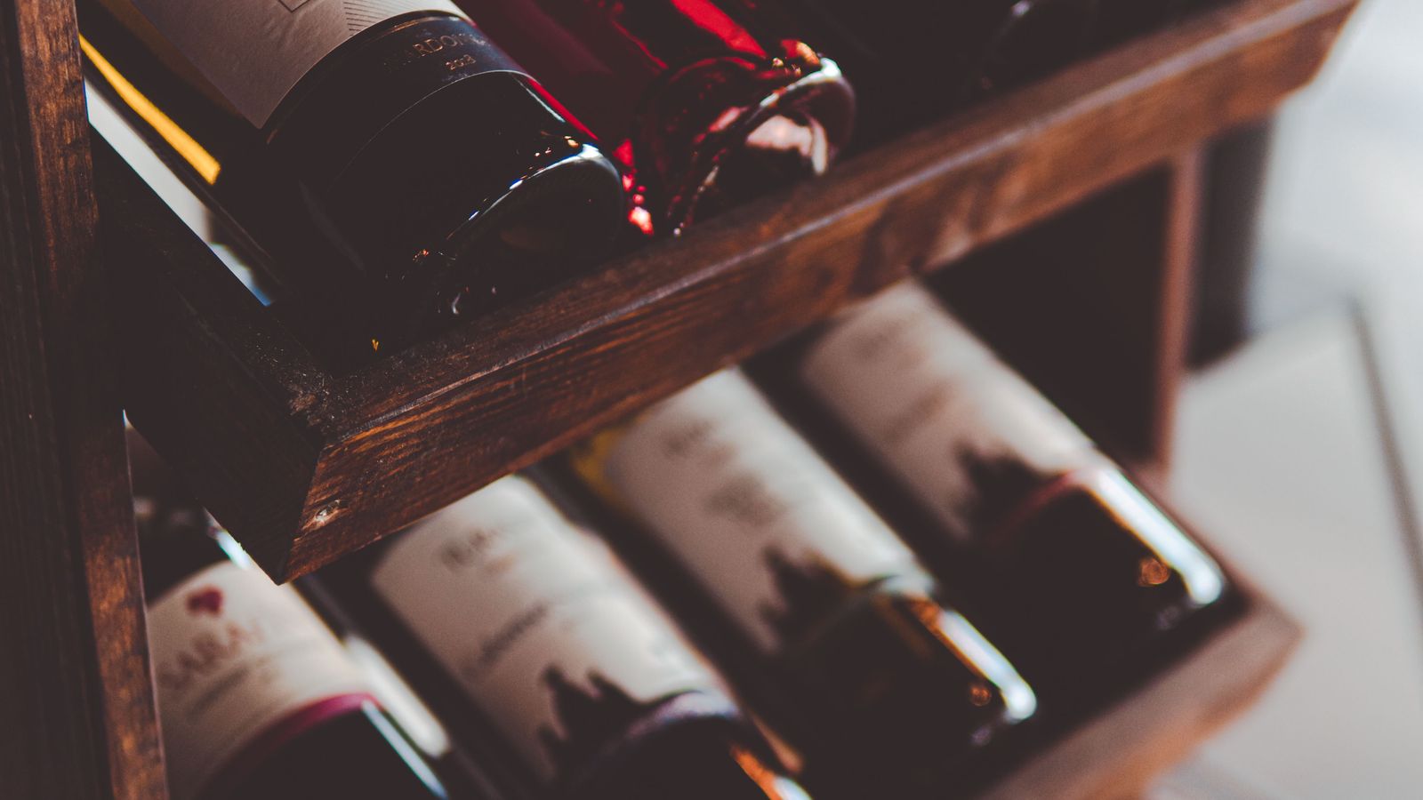 A wooden wine rack filled with bottles of red and white wine