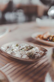 Delightful appetizer served on a ceramic plate with fresh herbs in a soft focus setting.