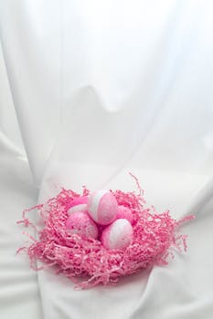 Delightful pastel pink Easter eggs in a stylish shredded nest.