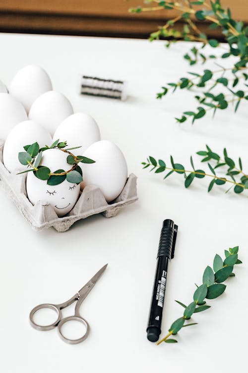 White Painted Egg Near Scissor and Pen