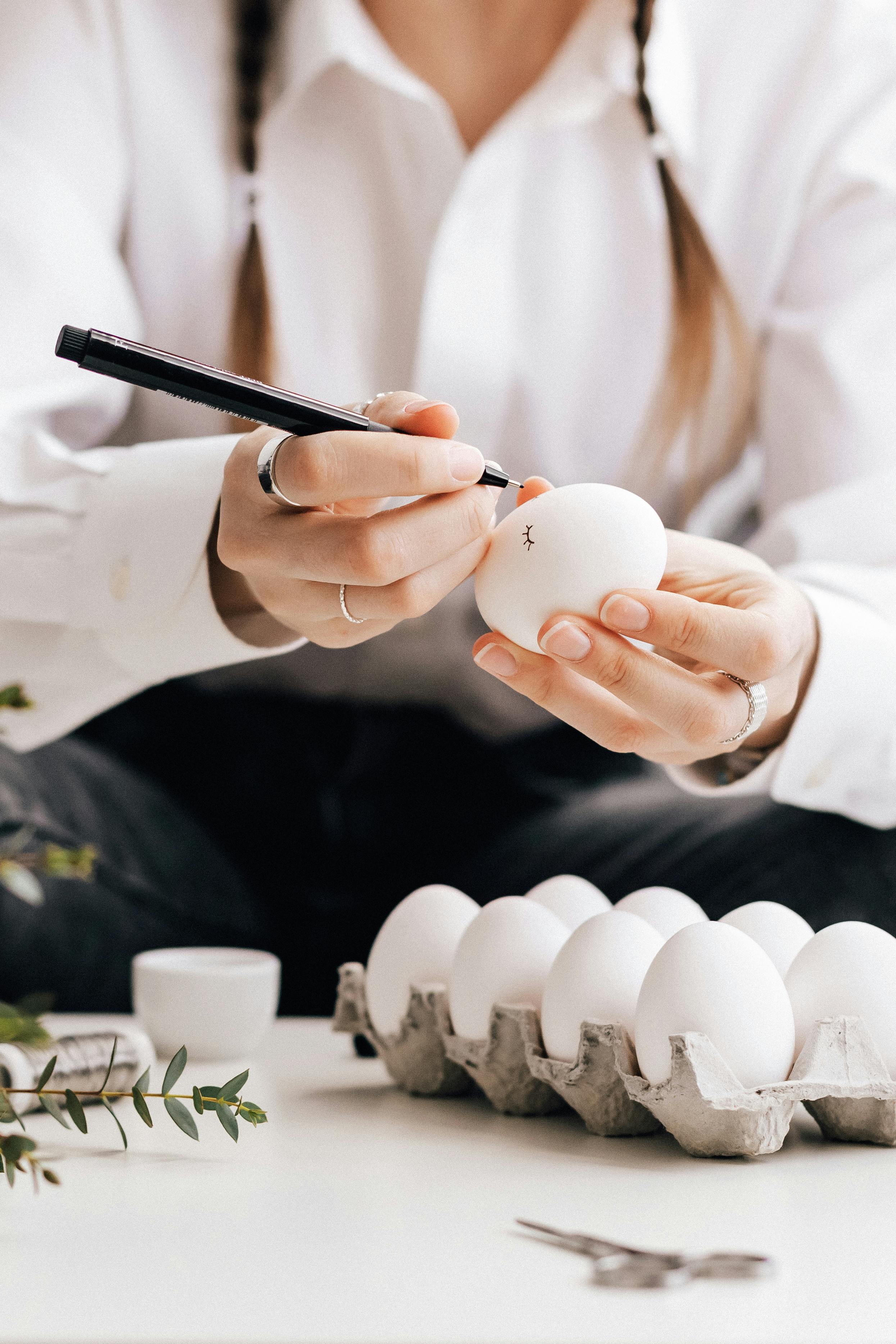 crop photo of man painting an egg