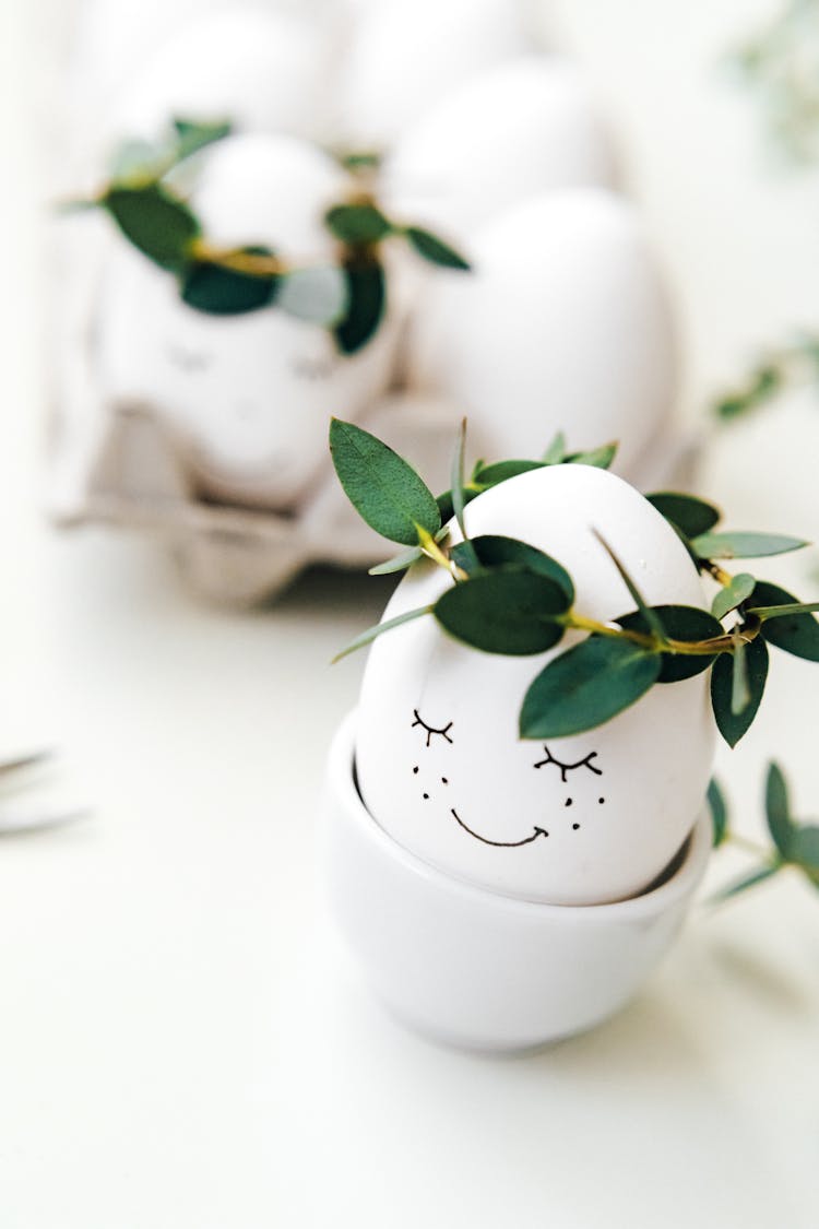 White Painted Eggs With Crown Of Green Leaves