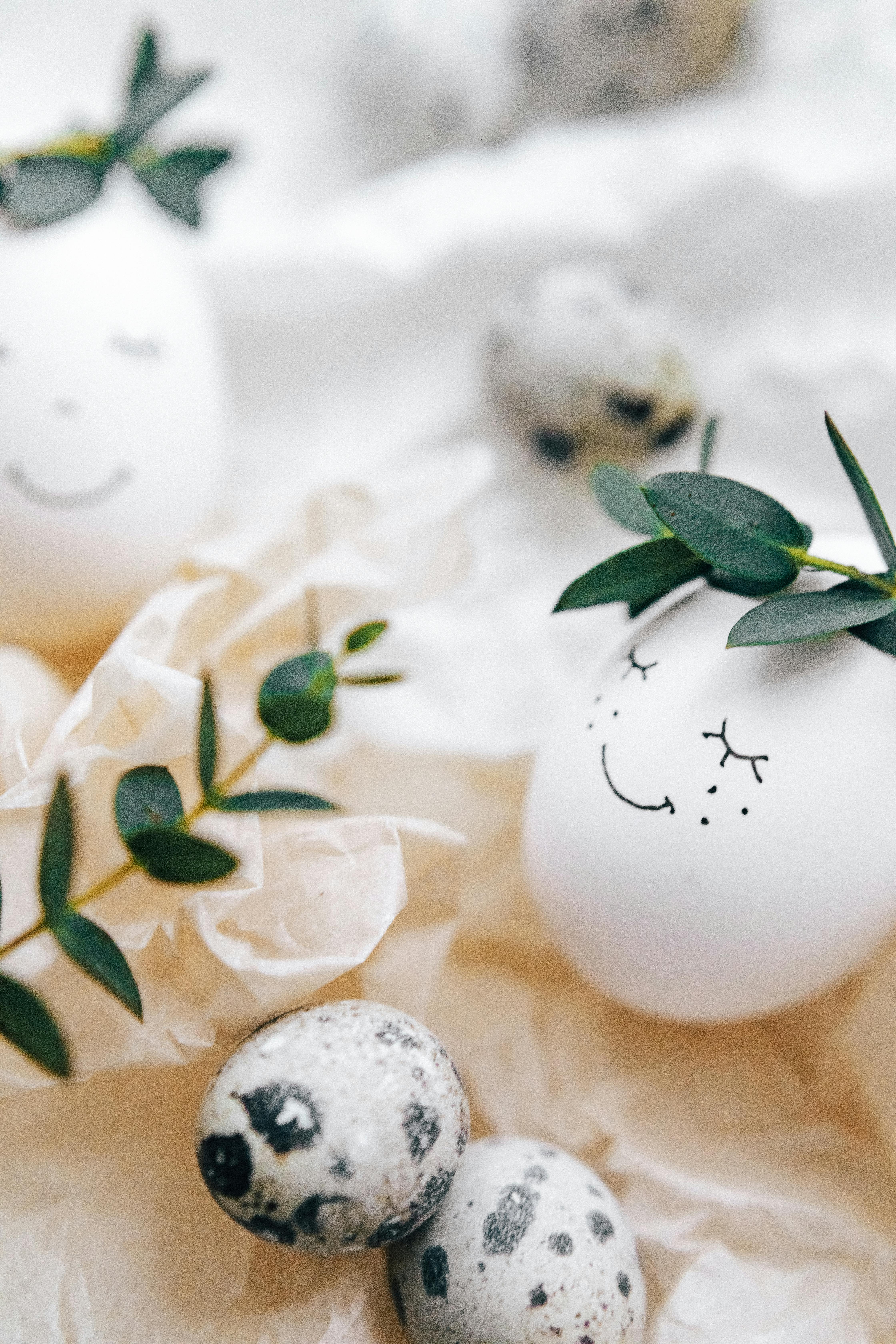 white painted eggs with green leaves