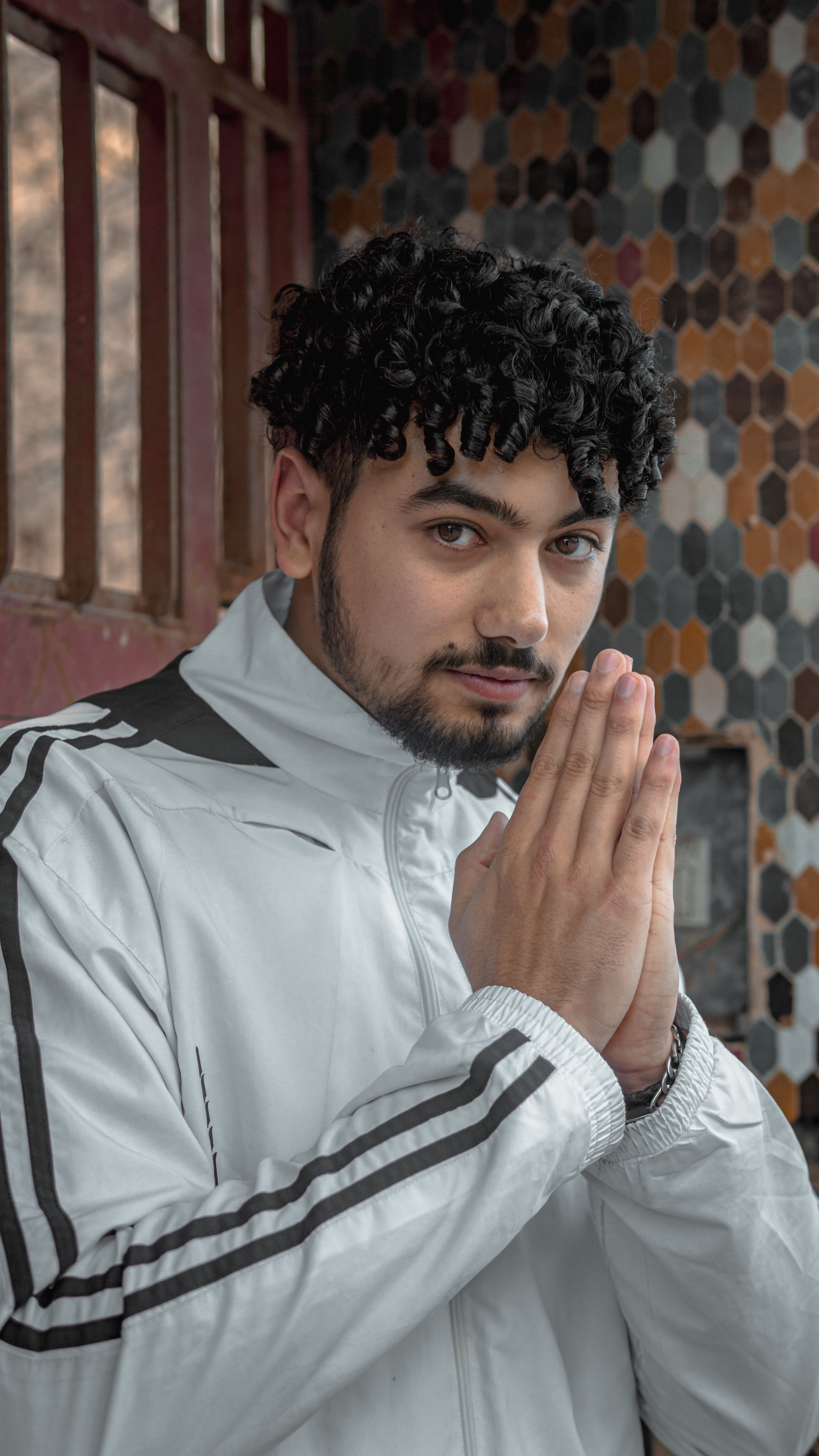 Portrait of a young man with curly hair in a traditional Moroccan setting, exuding a confident aura.
