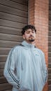 Handsome Man Standing Beside the Brown Brick Wall