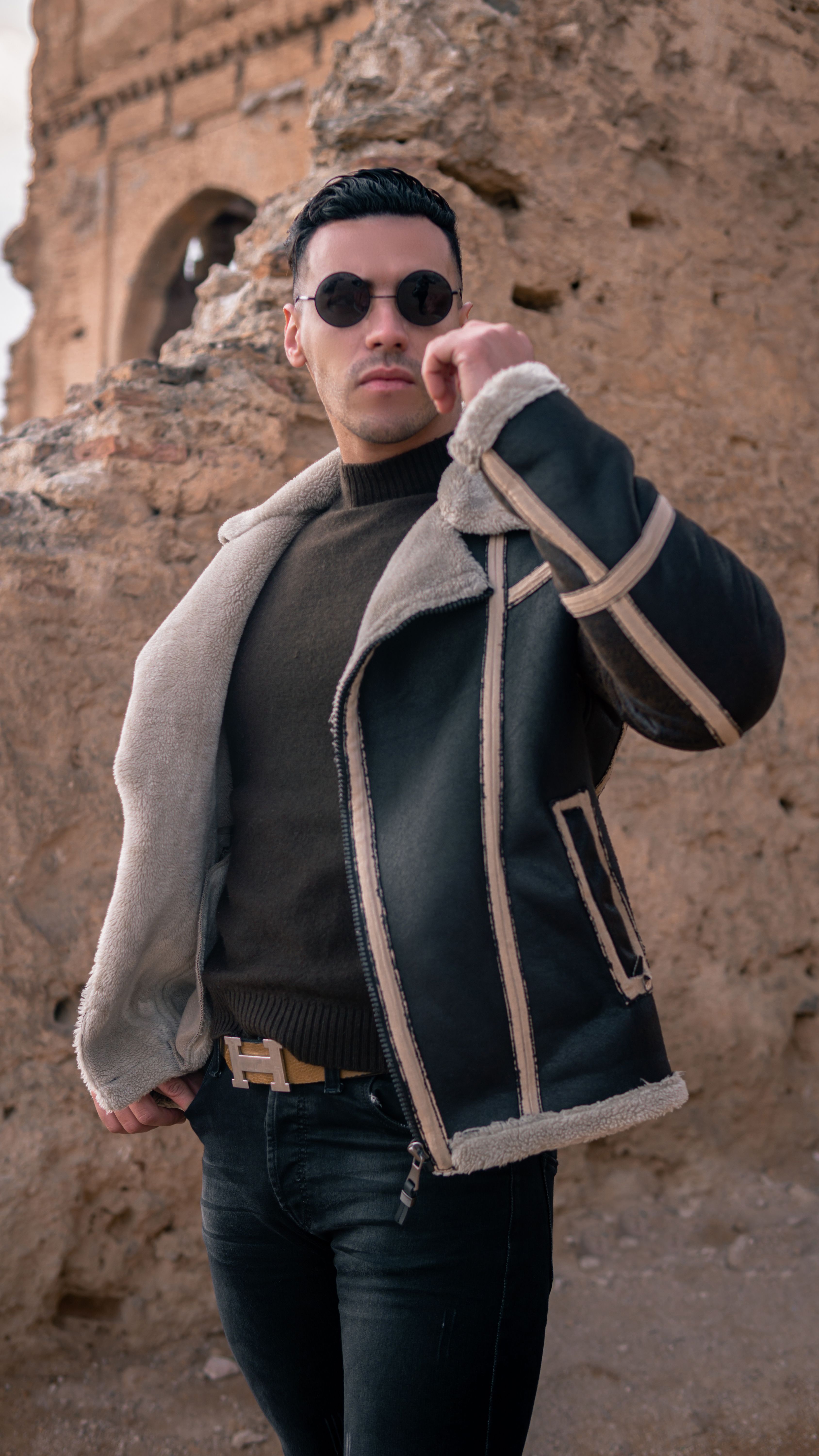 A Man in Black Jacket and Sunglasses Standing Near the Rock Formation ...