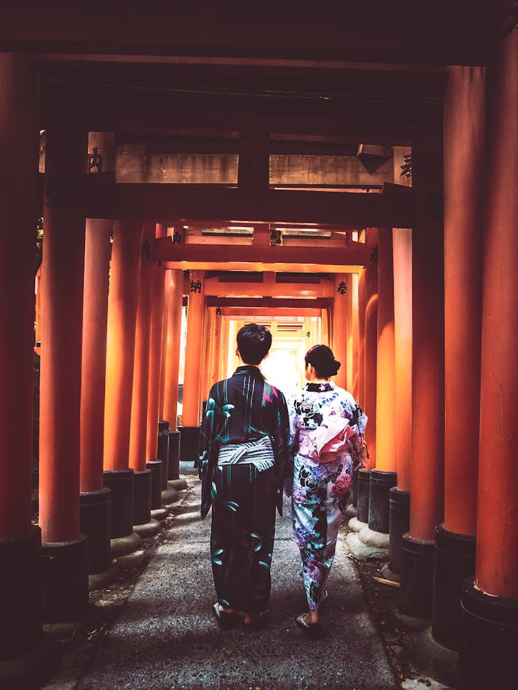 A Couple Wearing Kimonos Walking On Open Hallway