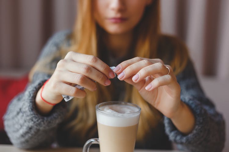 Woman Adding Sugar In Her Coffee